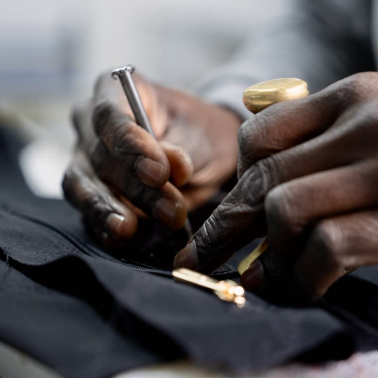 Hands fitting a zipper pull, up close